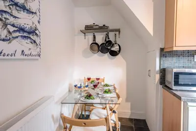 a small kitchen with a table with plates of food on it at Stones Throw, Aldeburgh in Aldeburgh