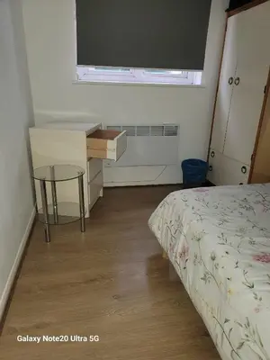 a bedroom with a bed and a desk and a table at The Home 2 in Mile End