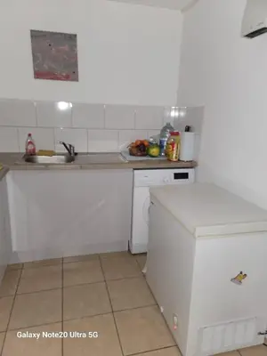 a white kitchen with a sink and a counter at The Home 2 in Mile End