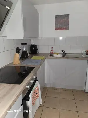 a kitchen with white cabinets and a stove top oven at The Home 2 in Mile End