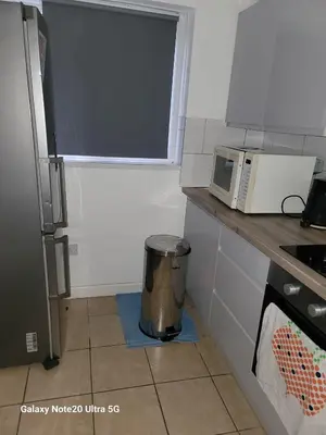 a kitchen with a microwave and a trash can at The Home 2 in Mile End