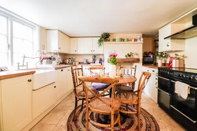 a kitchen with a table and chairs in it at Beautifully Designed Cottage Free WiFi in Rivenhall