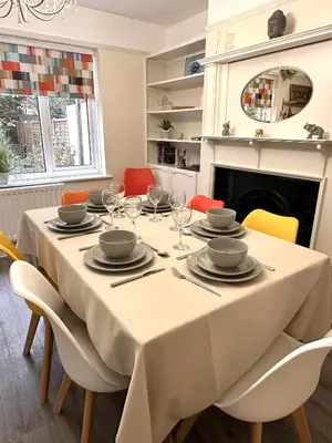 a dining room with a table with chairs and a fireplace at The Tudors Modern 3-Bed Home with Fast WiFi, Private Drive & Near Town Center in Chelmsford