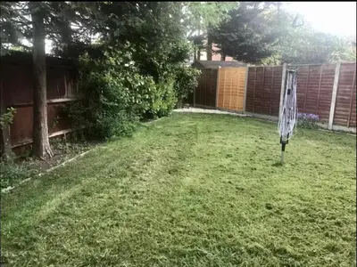 a yard with a net in the grass at The Tudors Modern 3-Bed Home with Fast WiFi, Private Drive & Near Town Center in Chelmsford