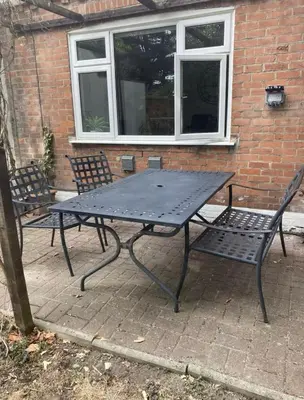 a picnic table and two chairs in front of a building at The Tudors Modern 3-Bed Home with Fast WiFi, Private Drive & Near Town Center in Chelmsford
