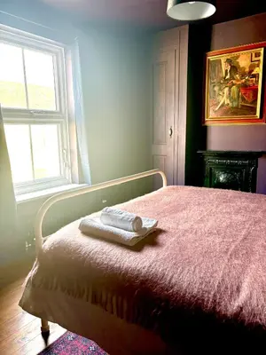 a bedroom with a bed with two towels on it at Hurrell Cottage in Cambridge