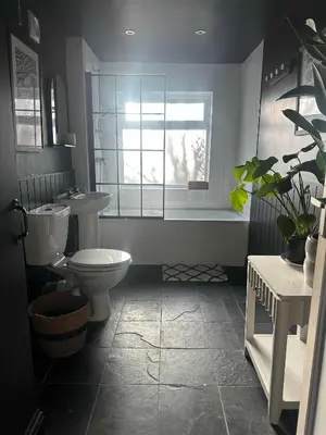a bathroom with a toilet and a sink and a window at Hurrell Cottage in Cambridge