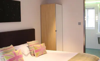 a bedroom with a bed with pillows and a closet at The Bell Inn Hotel in Horndon on the Hill