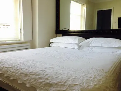 a bedroom with a bed with white sheets and pillows at The Bell Inn Hotel in Horndon on the Hill