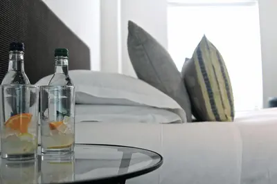 two bottles on a glass table next to a couch at The Bell Inn Hotel in Horndon on the Hill