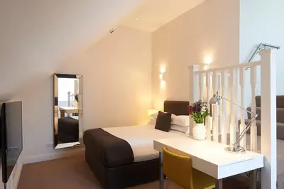 a bedroom with a bed and a table with a desk at The Bell Inn Hotel in Horndon on the Hill