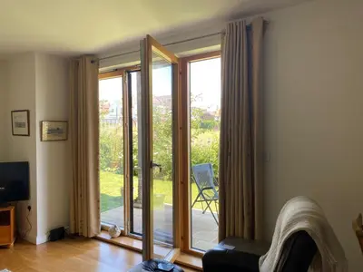 a living room with a sliding glass door at Alices’s Beachside Haven in Harwich