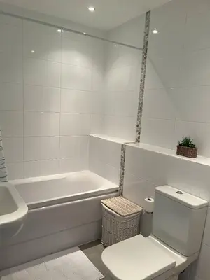a bathroom with a toilet and a tub and a sink at Alices’s Beachside Haven in Harwich