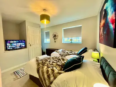 a bedroom with two beds and a television in it at 4 Bedroom House - DISC0UNTS - Parking, Contractors, Group, Family in Colchester