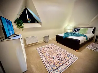 a bedroom with a bed and a television and a rug at 5 Bedroom House - DISC0UNTS - Parking, Contractors, Crew, Group, Family in Colchester