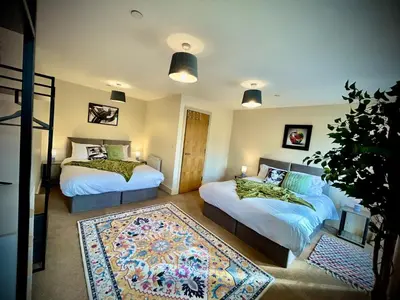 a bedroom with two beds and a rug at 5 Bedroom House - DISC0UNTS - Parking, Contractors, Crew, Group, Family in Colchester