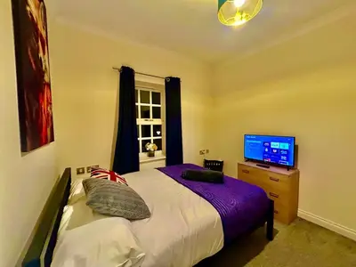 a bedroom with a bed and a flat screen tv at 5 Bedroom House - DISC0UNTS - Parking, Contractors, Group, Family in Colchester