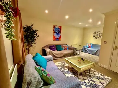 a living room with a couch and a table at 5 Bedroom House - DISC0UNTS - Parking, Contractors, Group, Family in Colchester