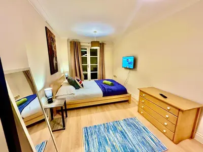 a bedroom with a bed and a desk and a mirror at 5 Bedroom House - DISC0UNTS - Parking, Contractors, Group, Family in Colchester