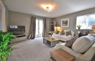 a living room with a couch and a tv at Family home in Great Dunmow for up to 5 guests in Great Dunmow