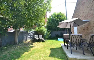 a patio with a table and an umbrella at Family home in Great Dunmow for up to 5 guests in Great Dunmow