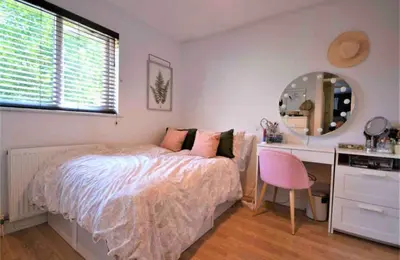 a bedroom with a bed and a desk and a mirror at Family home in Great Dunmow for up to 5 guests in Great Dunmow