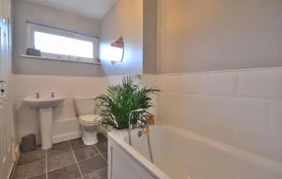 a bathroom with a tub and a toilet and a sink at Family home in Great Dunmow for up to 5 guests in Great Dunmow
