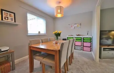 a dining room with a wooden table and chairs at Family home in Great Dunmow for up to 5 guests in Great Dunmow