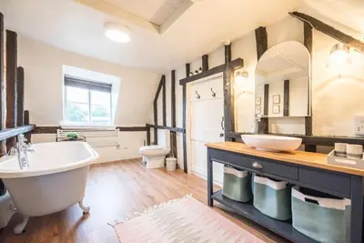 a bathroom with a tub and a sink and a toilet at The Old Cottage - Sudbourne, near Orford in Sudbourne