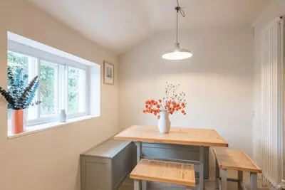 a dining room with a table and a vase with flowers at The Old Cottage - Sudbourne, near Orford in Sudbourne