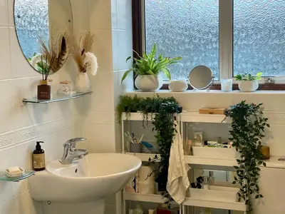 a bathroom with a sink and a window with plants at Lea Valley Nature Reserve Bright Home with Private Garden - 40 min to London by Train in Nazeing