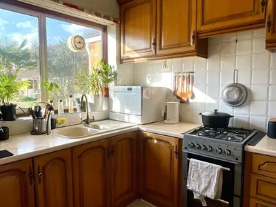 a kitchen with a stove and a sink and a window at Lea Valley Nature Reserve Bright Home with Private Garden - 40 min to London by Train in Nazeing