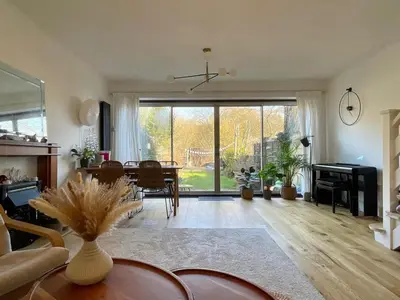 a living room with a table and a large window at Lea Valley Nature Reserve Bright Home with Private Garden - 40 min to London by Train in Nazeing