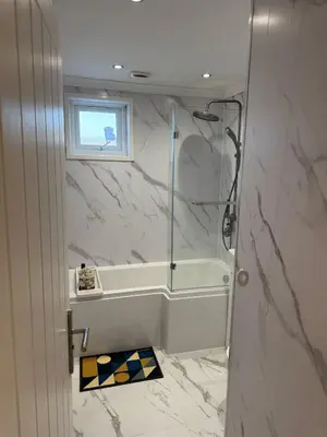 a bathroom with a shower with a tub and a window at Paramount Luxe Loft- 3 bedrooms, 4 beds cosy home in Laindon