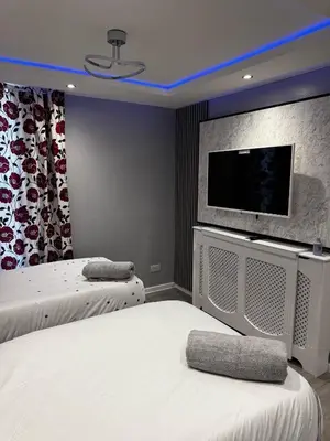 a bedroom with two beds and a flat screen tv at Paramount Luxe Loft- 3 bedrooms, 4 beds cosy home in Laindon
