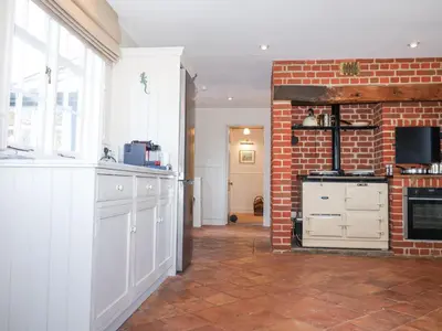 a kitchen with white cabinets and a brick wall at Holm Oak Lodge in Clacton-on-Sea