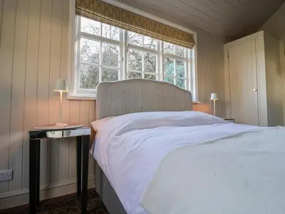a bedroom with a white bed and a window at The Woodshed in Clacton-on-Sea