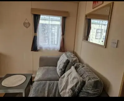 a living room with a couch and a table at House of Eminence Holidays in Saint Osyth