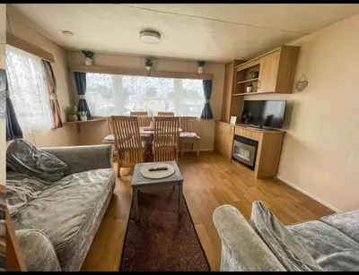 a living room with a couch and a table at House of Eminence Holidays in Saint Osyth