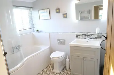 a bathroom with a tub and a toilet and a sink at Beautifully refurbished 3 bedroom cottage in Ashdon