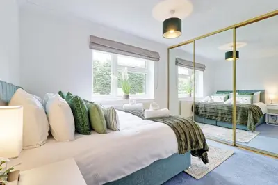 a bedroom with a large bed and a mirror at Luxury 4-Bed Family Home in Epping with Parking by LMV Property in Epping