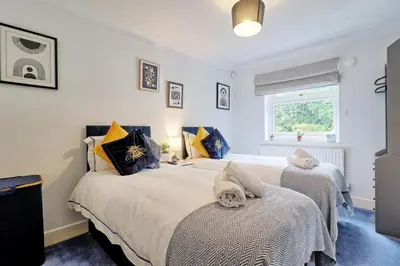 a bedroom with two beds and a window at Luxury 4-Bed Family Home in Epping with Parking by LMV Property in Epping
