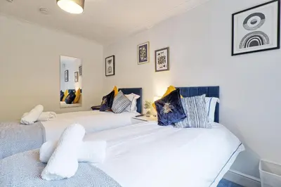 two beds in a room with white walls at Luxury 4-Bed Family Home in Epping with Parking by LMV Property in Epping