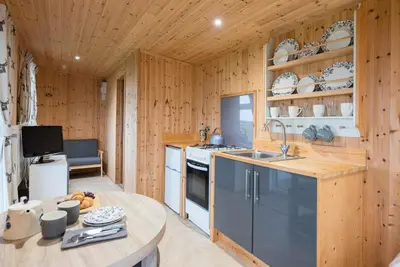 a kitchen with wooden walls and a table in a room at River Lodge, Aldeburgh in Aldeburgh