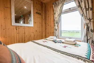 a bedroom with a large bed with a window at River Lodge, Aldeburgh in Aldeburgh