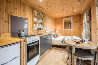 a kitchen with a table and a bed in a room at River Lodge, Aldeburgh in Aldeburgh
