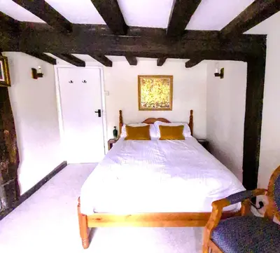a bedroom with a large white bed with yellow pillows at Secluded 16th Century Farmhouse with private grounds in Hatfield Peverel