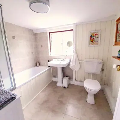 a bathroom with a sink and a tub and a toilet at Secluded 16th Century Farmhouse with private grounds in Hatfield Peverel