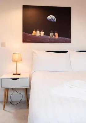 a bedroom with a white bed and a night stand with a lamp at Spacious 3-Bed Townhouse Florence Villa Near River & City in Chesterton