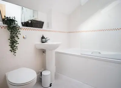 a white bathroom with a toilet and a sink at Spacious 3-Bed Townhouse Florence Villa Near River & City in Chesterton